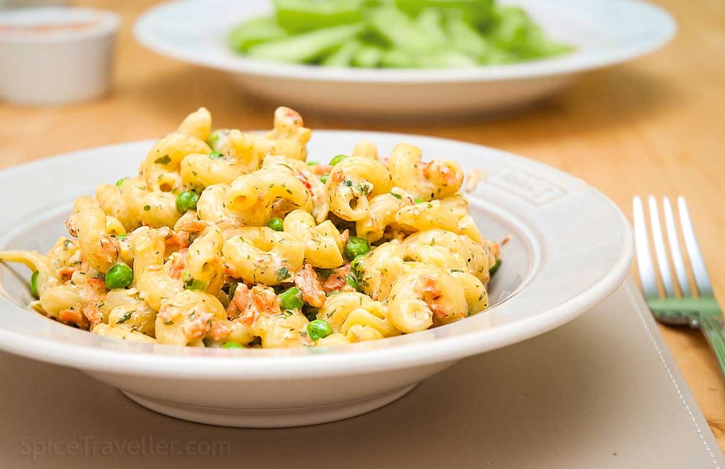 Deep plate with delicious creamy pasta Spirali, salmon and peas in white sauce.