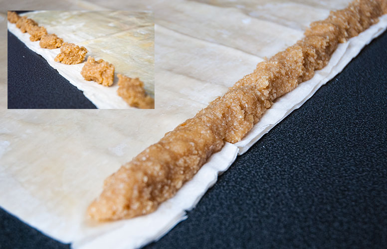 Step-by-step image guide: Spreading the luscious almond filling on a filo pastry sheet and rolling it for M'hanncha