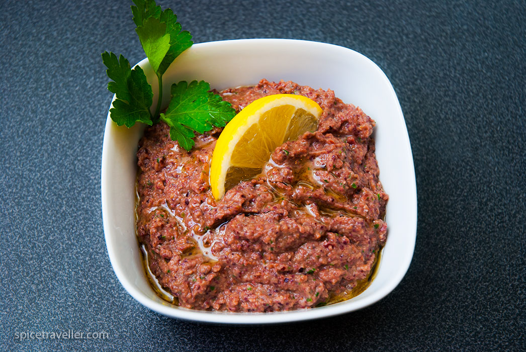 A bowl of homemade French tapenade, a flavorful blend of black olives, anchovies, garlic, and olive oil.