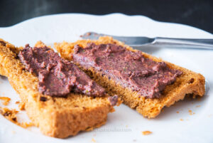 Two slices of homemade bread topped with French tapenade olive spread