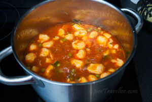 A pot filled with homemade Provençal soup with gnocchi, fresh vegetables, and aromatic herbs.