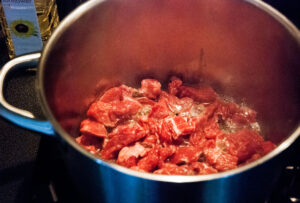 beef cubes frying in a pot