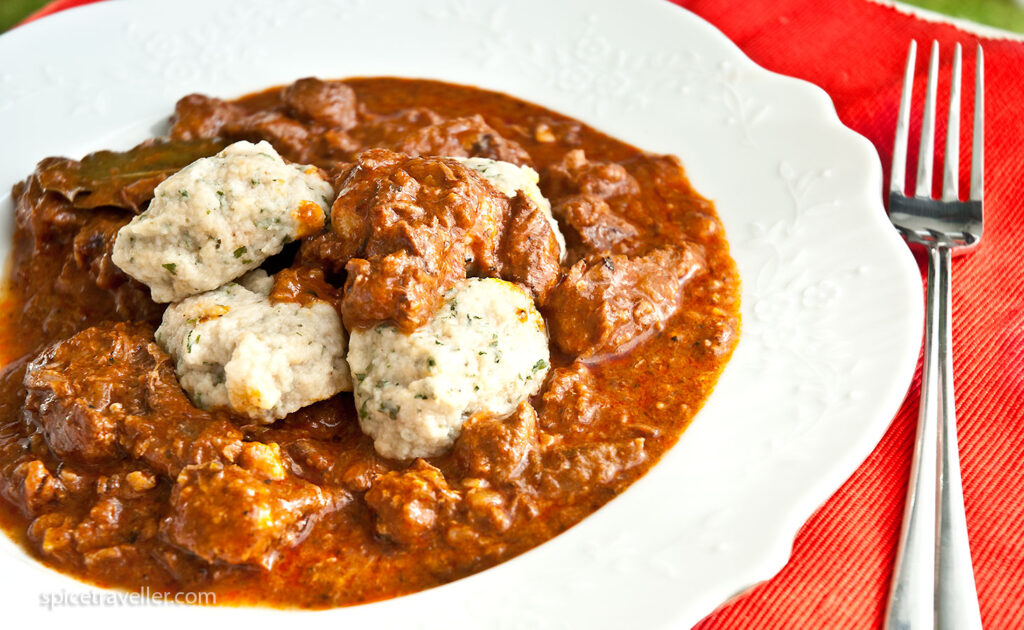 A delicious plate of Wiener Saftgulasch, a traditional Austrian beef stew with a thick and flavorful sauce, served with dumplings