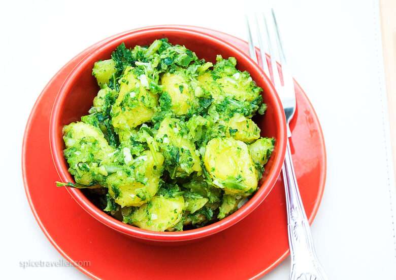 kale and potato side dish in a red bowl