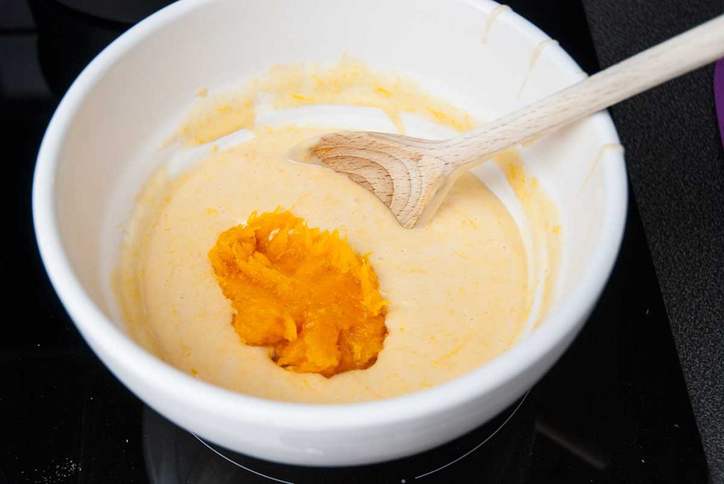 Adding pumpkin puree in the cake batter.