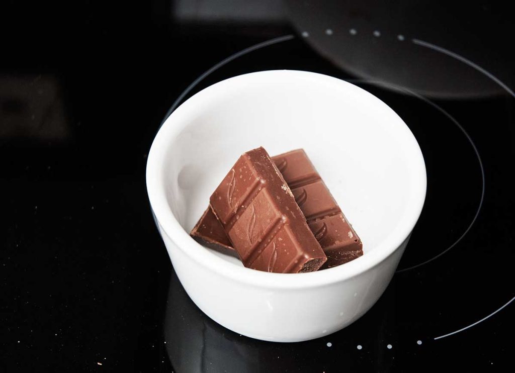 Chocolate squares in a small bowl ready to melt in microwave.