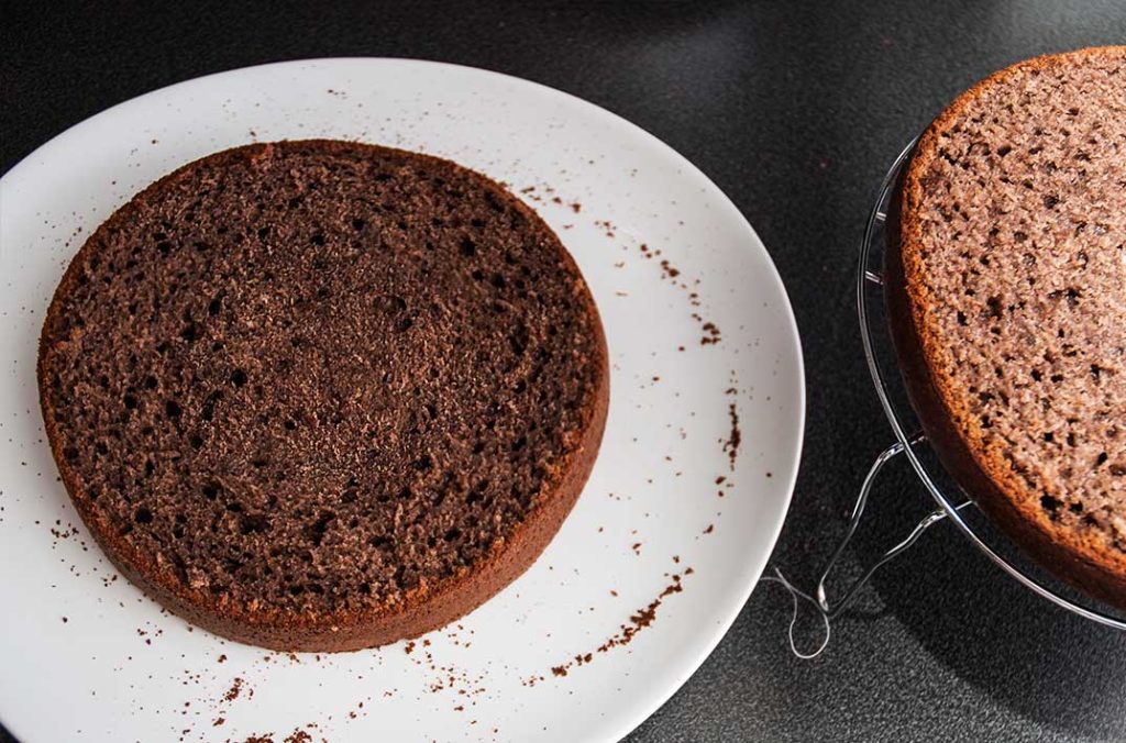 Perfectly cut walnut cake in half, two identical layers ready to make Halloween pumpkin and chocolate walnut cake.