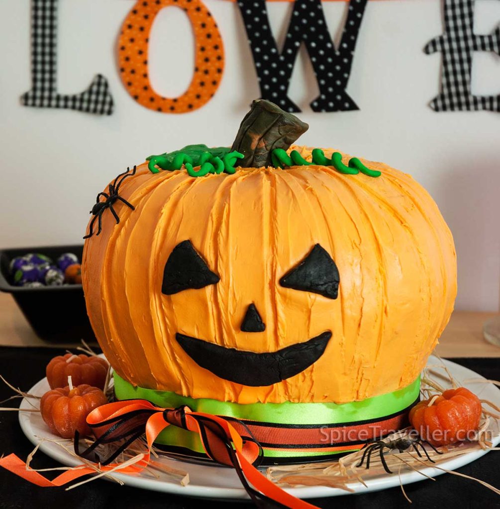 Jack-o-Lantern pumpkin and chocolate on the Halloween-themed table.