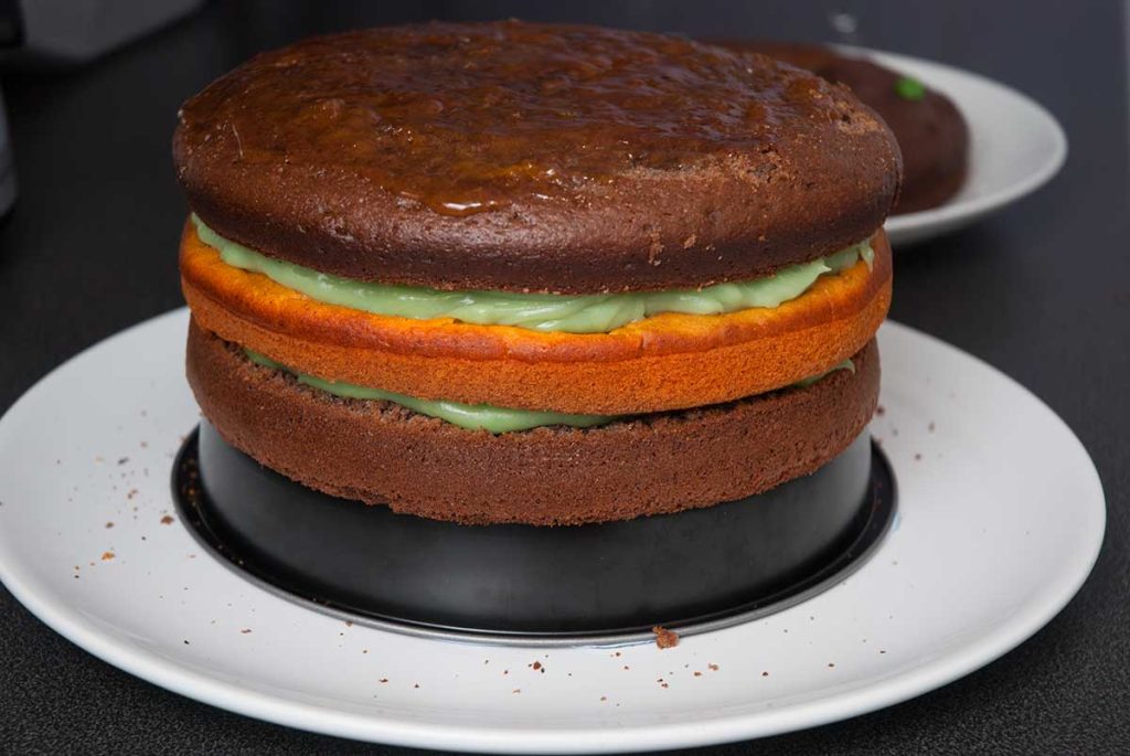 Adding third sponge cake layer and spread with apricot jam.