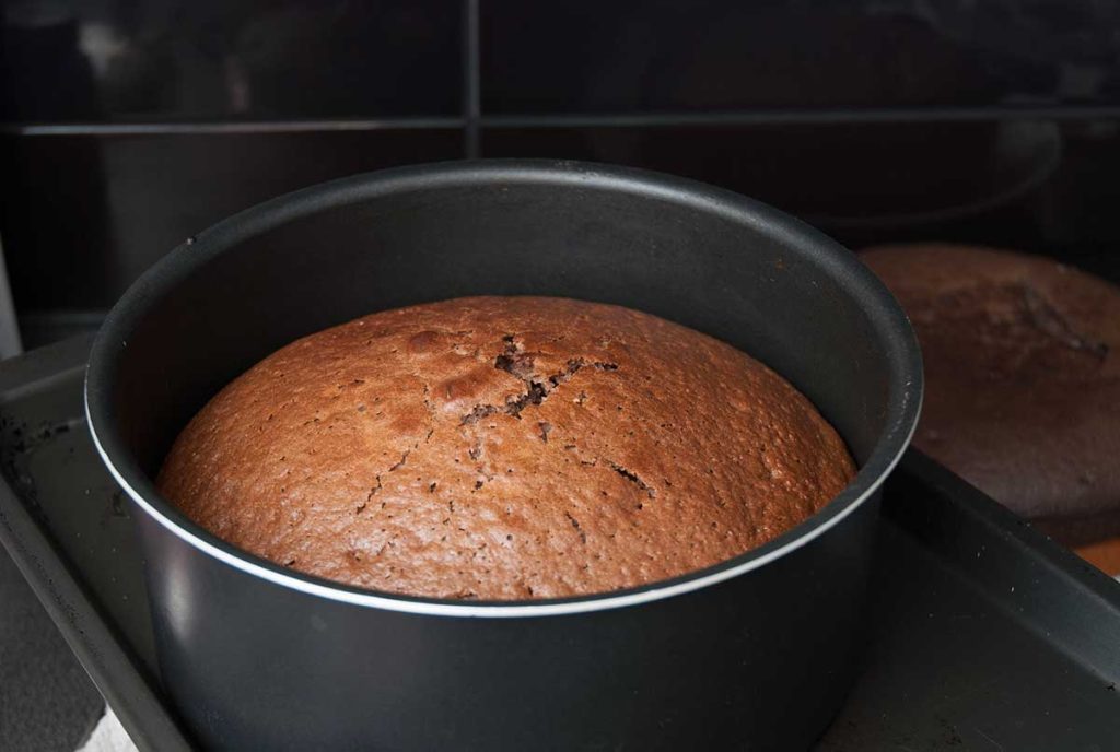 Cocoa and walnut cake baked in a round cake tin.