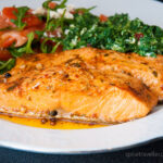 Wild salmon cooked in marinade, served with Mediterranean salad and spicy spinach