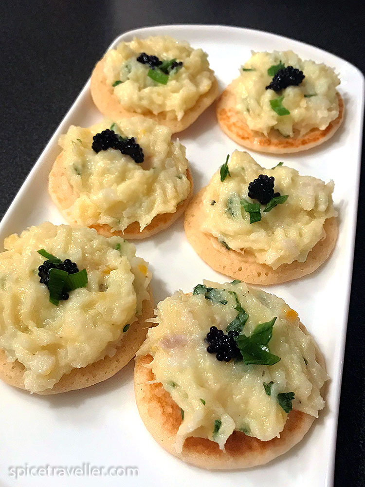 cod and crab pate ( mash) served on blini as a canape, decorated with parsley and caviar