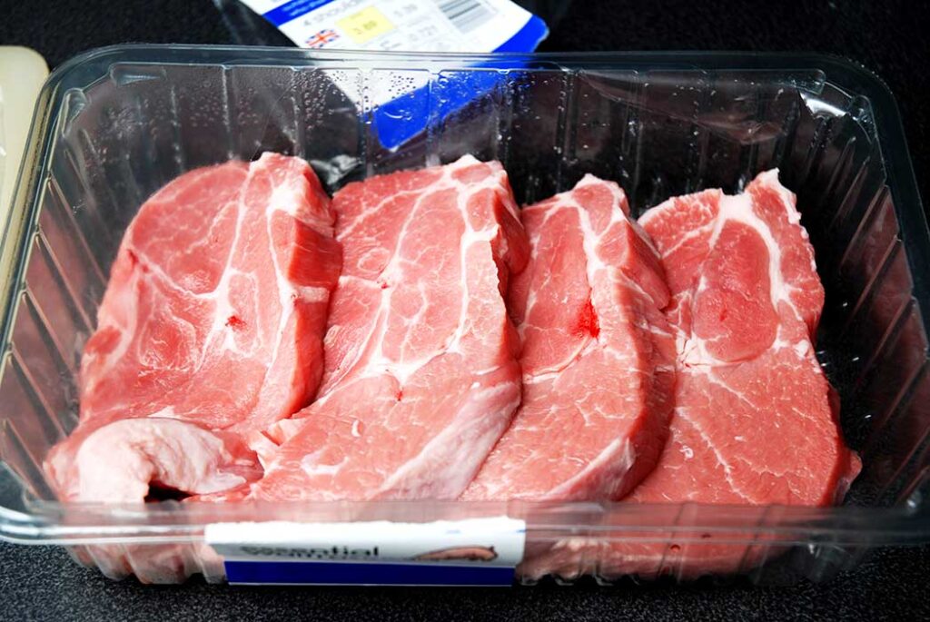 Four fresh pork shoulder steaks pack from supermarket