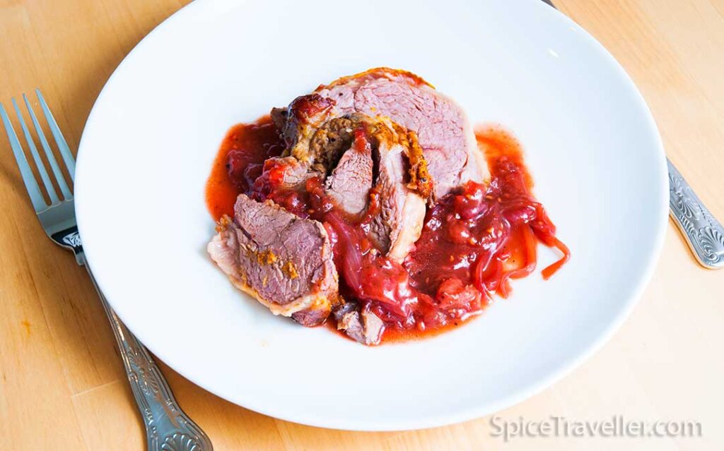 sliced rostaed lamb served with berry and balsamic sauce
