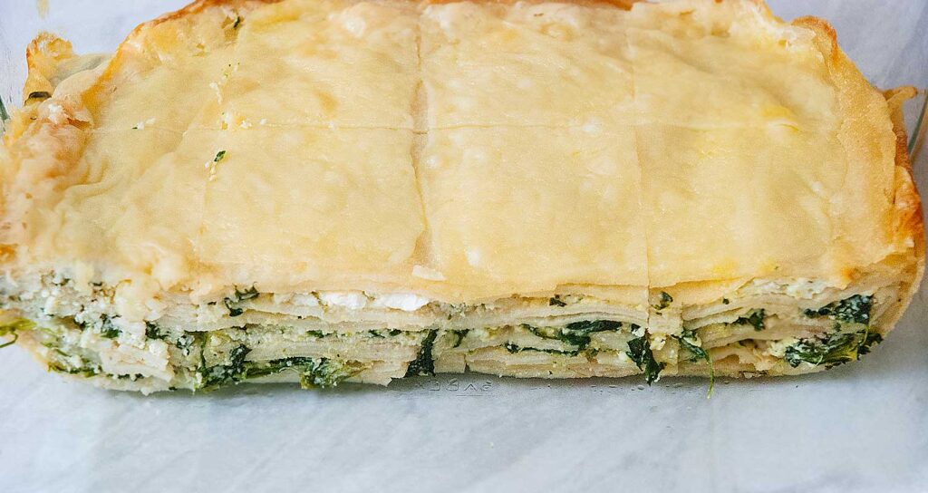 Greek Spanakopita with pancakes , freshly baked and cut into square portions