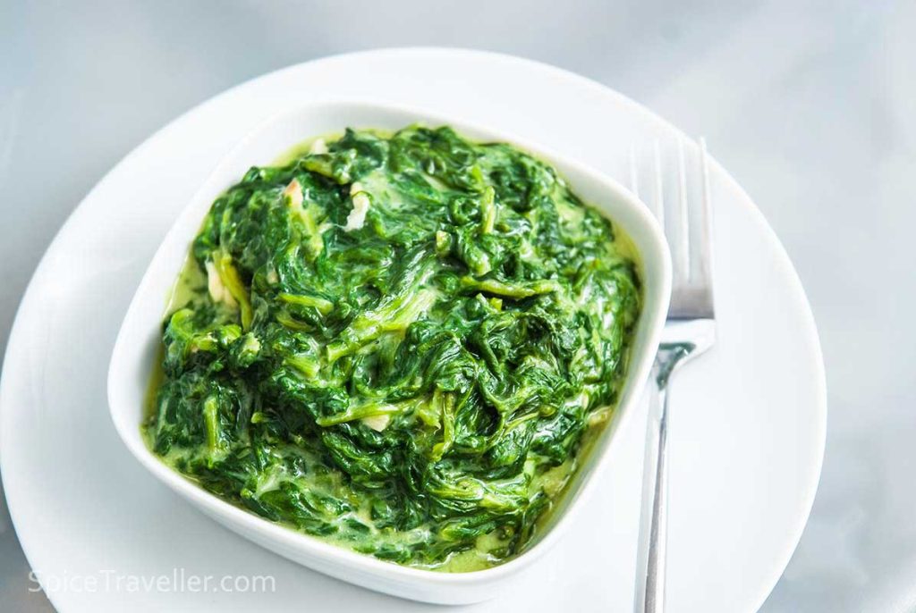 Simple creamy spinach Croatian style, served in a white rectangular bowl.
