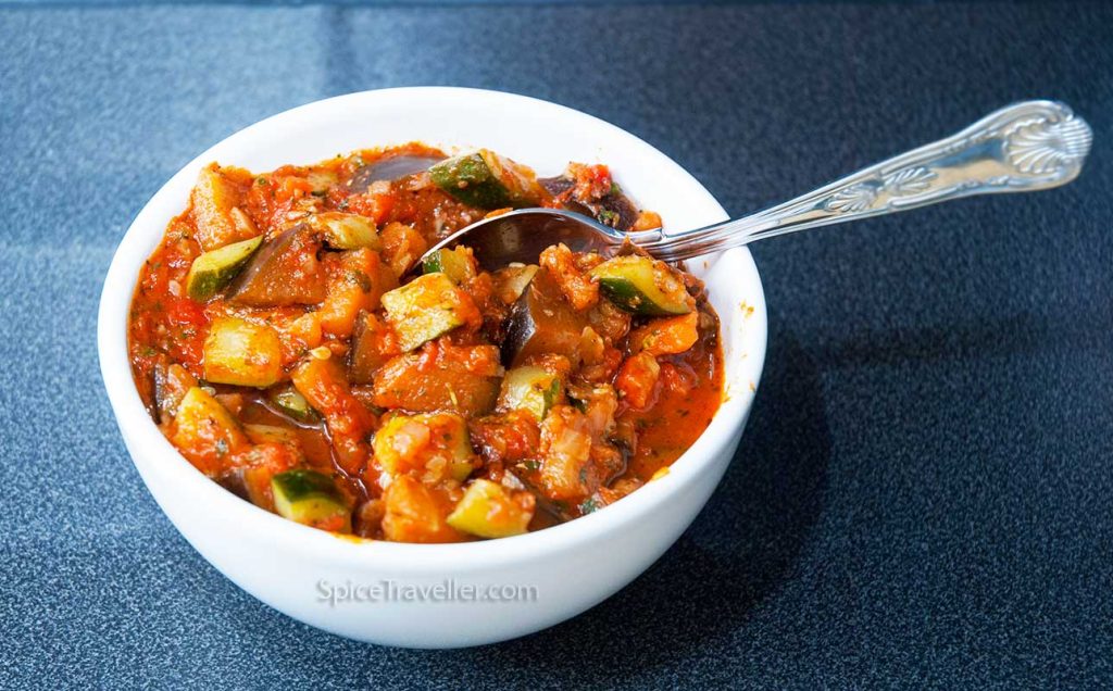 Delicious thick summer side dish with courgettes and aubergines served in white bowl
