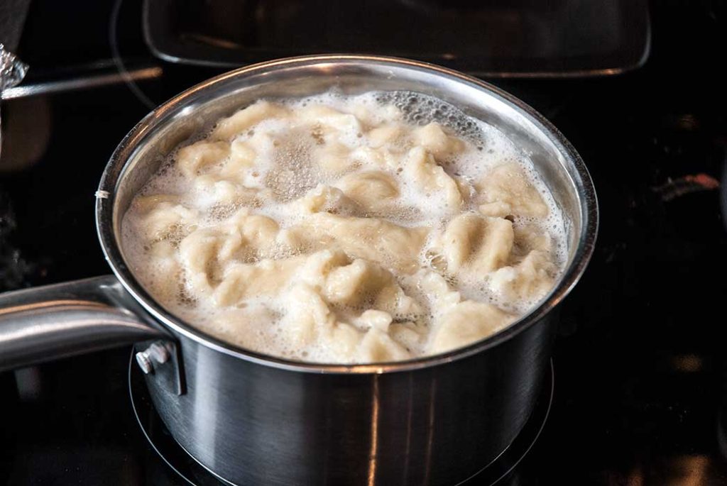 Small Hungarian dumplings cooking in boiling water.