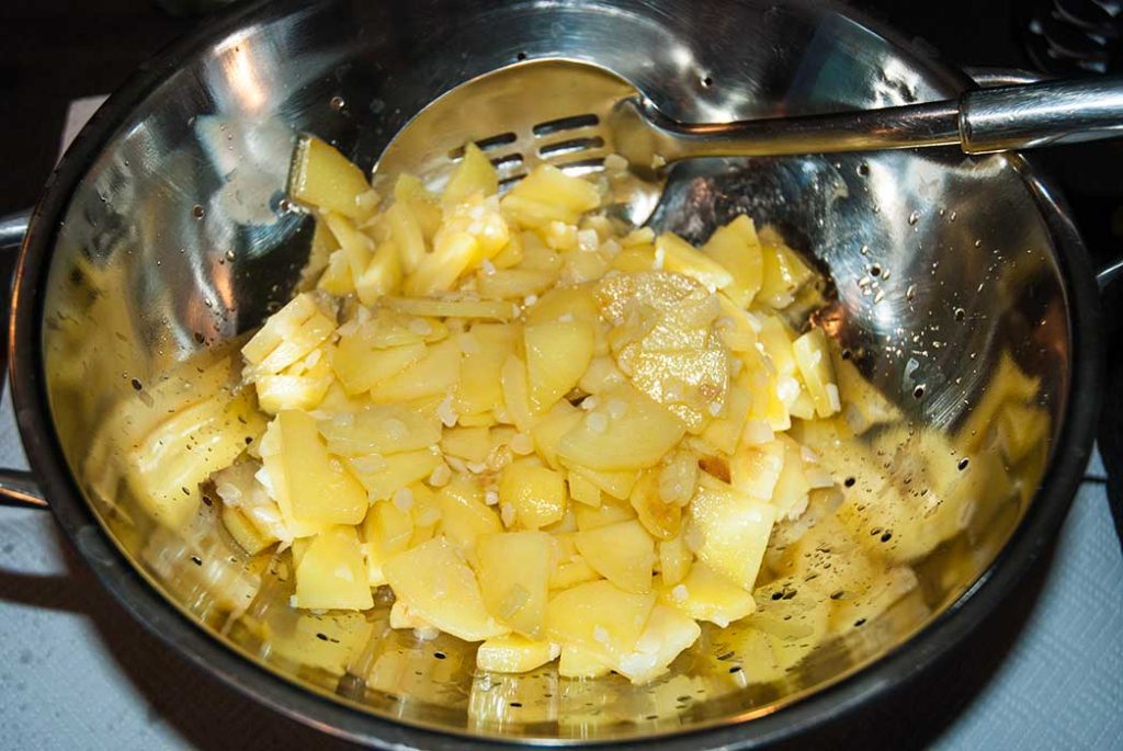 Drained potatoes and onions ready to mix with beaten eggs