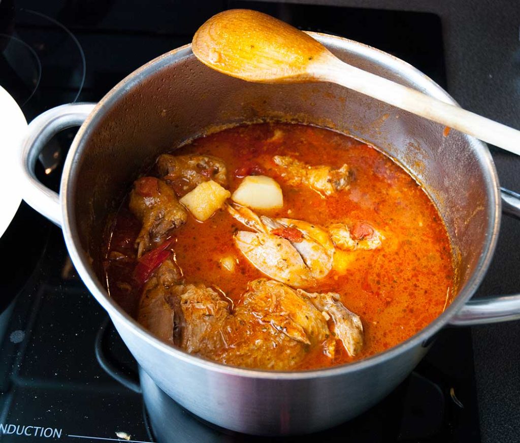 Pollo Guisado cooked in a large pot