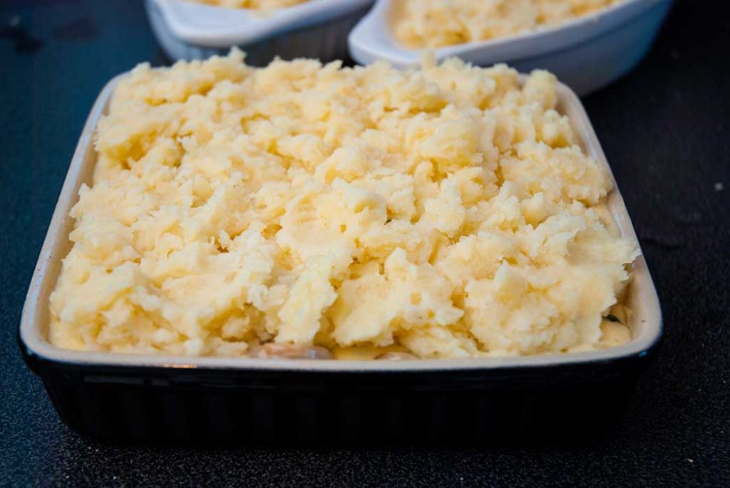 baking dsh filled with fish, seafood and creamy sauce, topped with mashed potato, step three