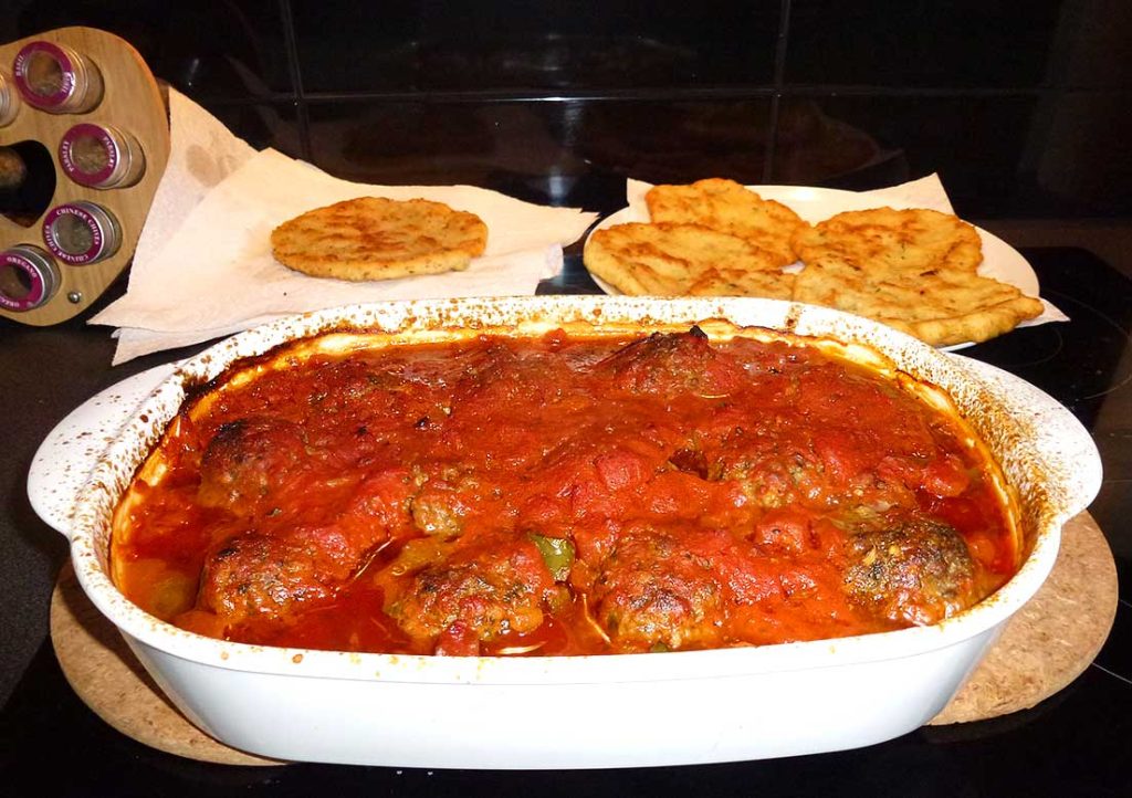 Freshly baked Turkish meatballs and potatoes in tomato sauce. 