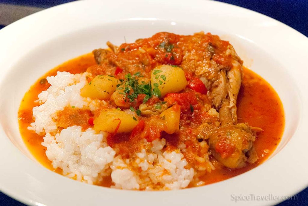 Delicious Pollo Guisado chicken stew served with plain rice