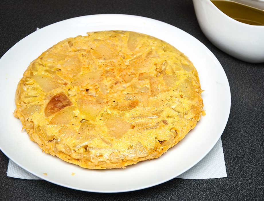 Spanish tortilla potato omelette perfectly done and served on white plate