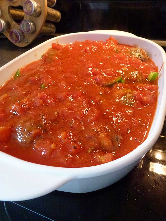 Aromatic sauce poured over turkish meatballs ready to bake