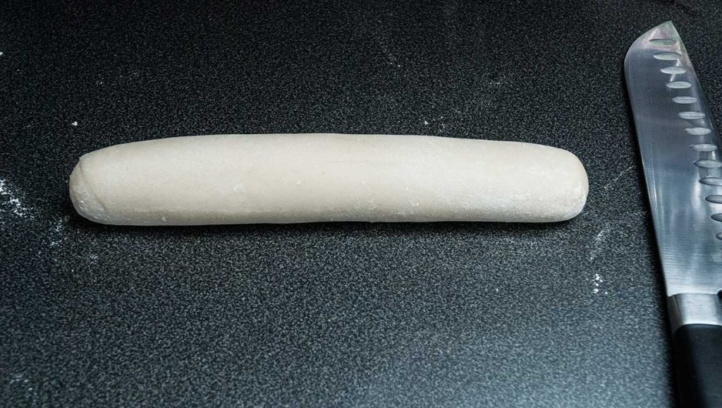 Long shaped dough ready to cut into smaller pieces.