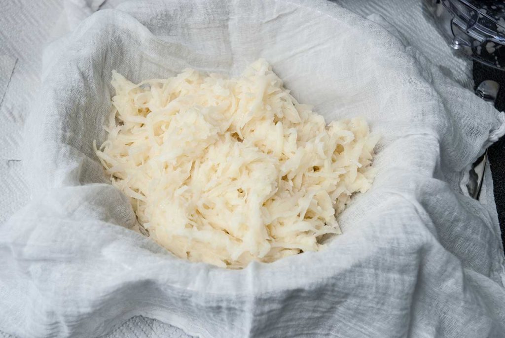 Grated potatoes in a cheesecloth.