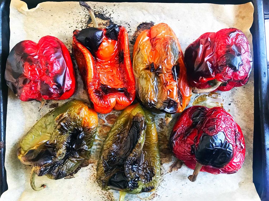 Perfectly roasted large bell peppers on a baking tray.