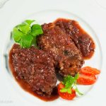 Three Salisbury steaks served with fresh tomato slices