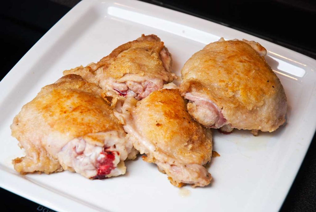 Seared chicken thighs ready for French Hunter's Chicken preparation.