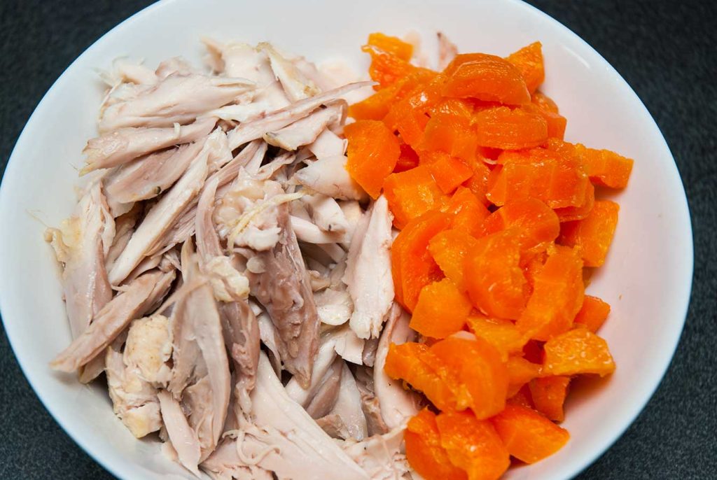 Cooked chicken meat and chopped carrots ready to use.