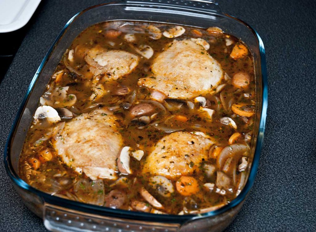 French Hunter's Chicken pieces covered with mushrooms sauce ready to bake.