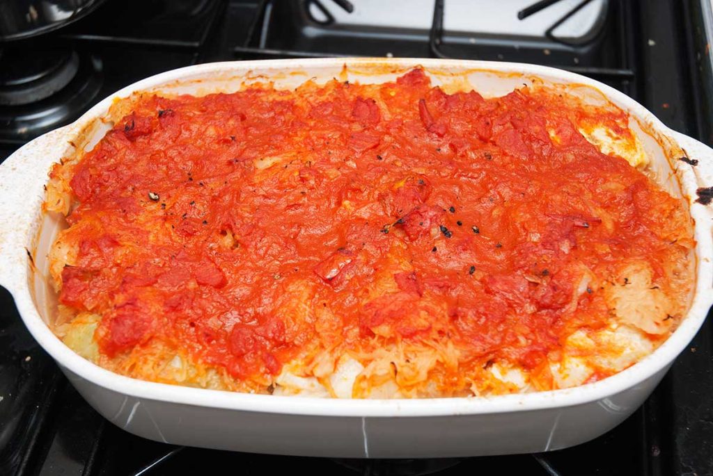 Perfectly baked POlish stuffed cabbage - golabki - covered in rich tomato sauce, freshly out of the oven and ready to serve.