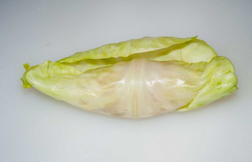 A rolled cabbage leaf with the filling inside, with sides to be tucked in.