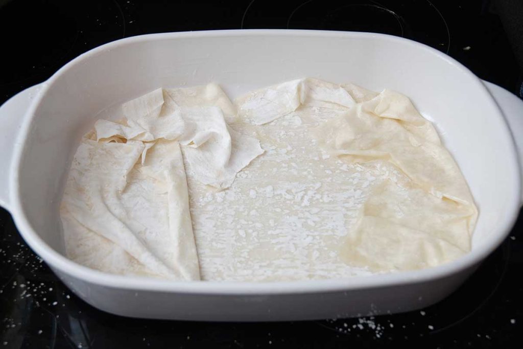 Baking tray with a single sheet of filo pastry laid out.