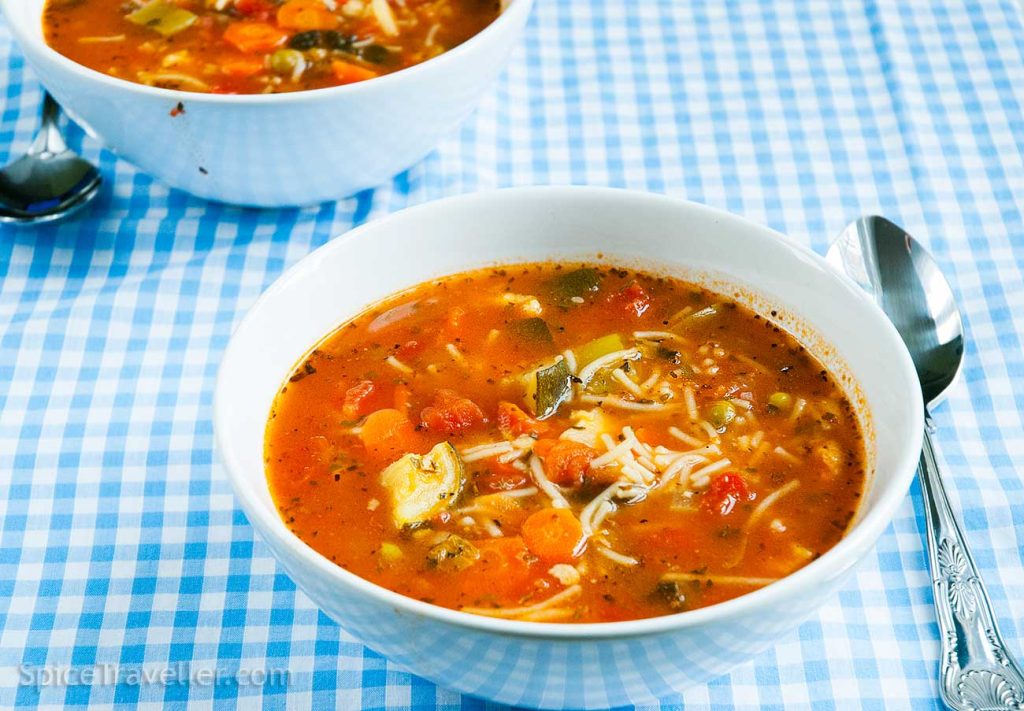 Bowl of delicious Italian Minestrone soup with various vegetables and Spaghettini pasta in tomato based broth.