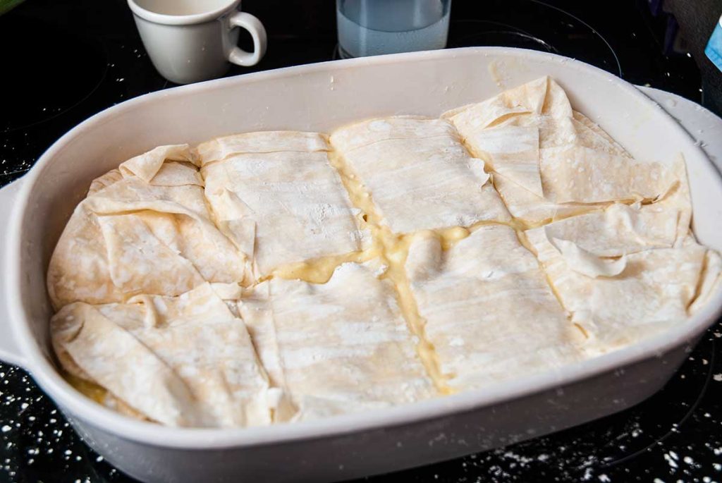 Slice banitsa into squares before pouring the egg and sparkling water mixture.