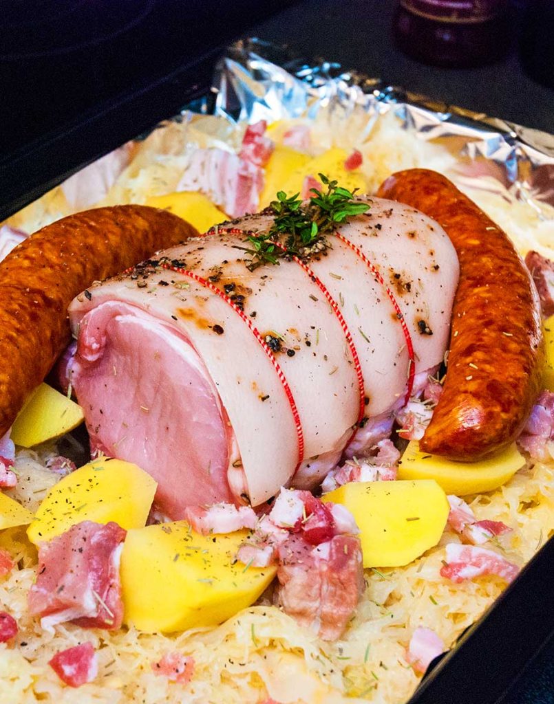 Variation - Pork loin with sauerkraut , sliced potatoes and Chorizo sausages ready to roast. 