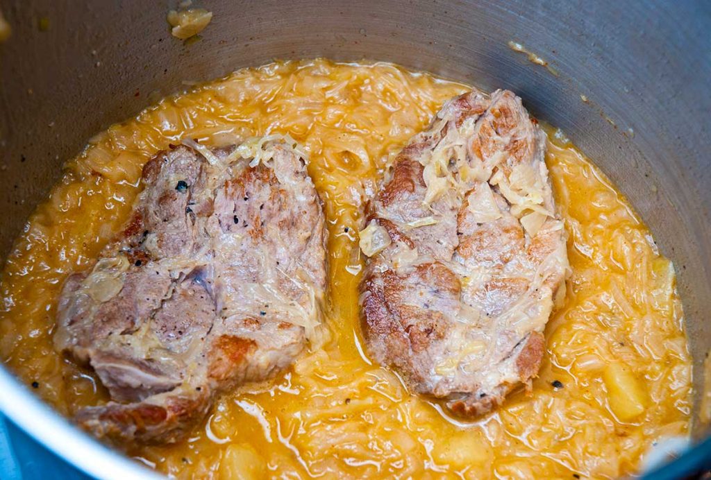 Pork steaks with sauerkraut in white wine sauce.