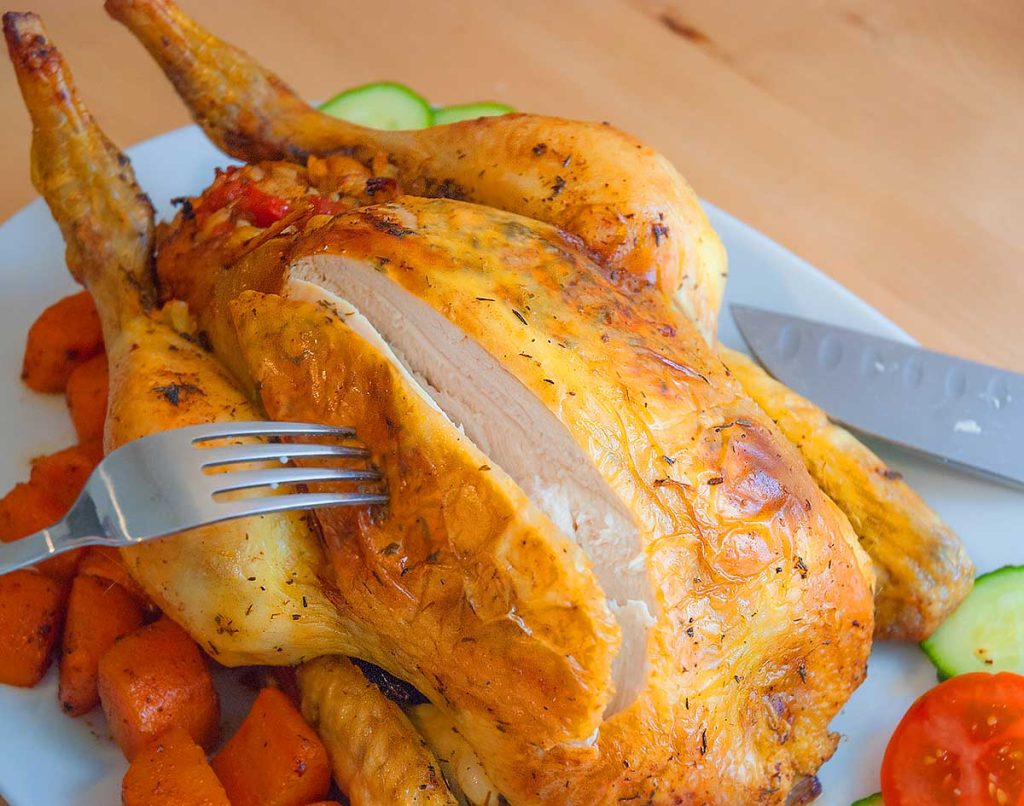 Close up of slicing into roasted chicken breast.