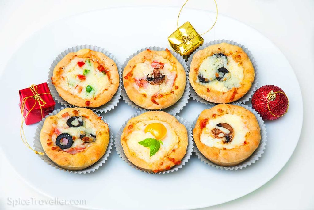 Six mini piza cupcakes selection on a white serving plate.