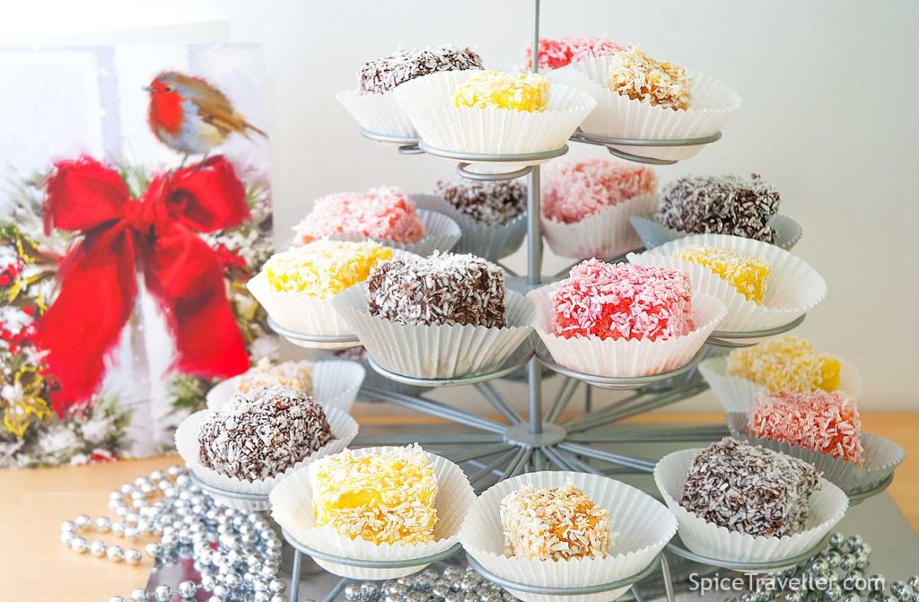 Festive looking colourful Lamingtons in cupcake casing served on tiered cake stand.