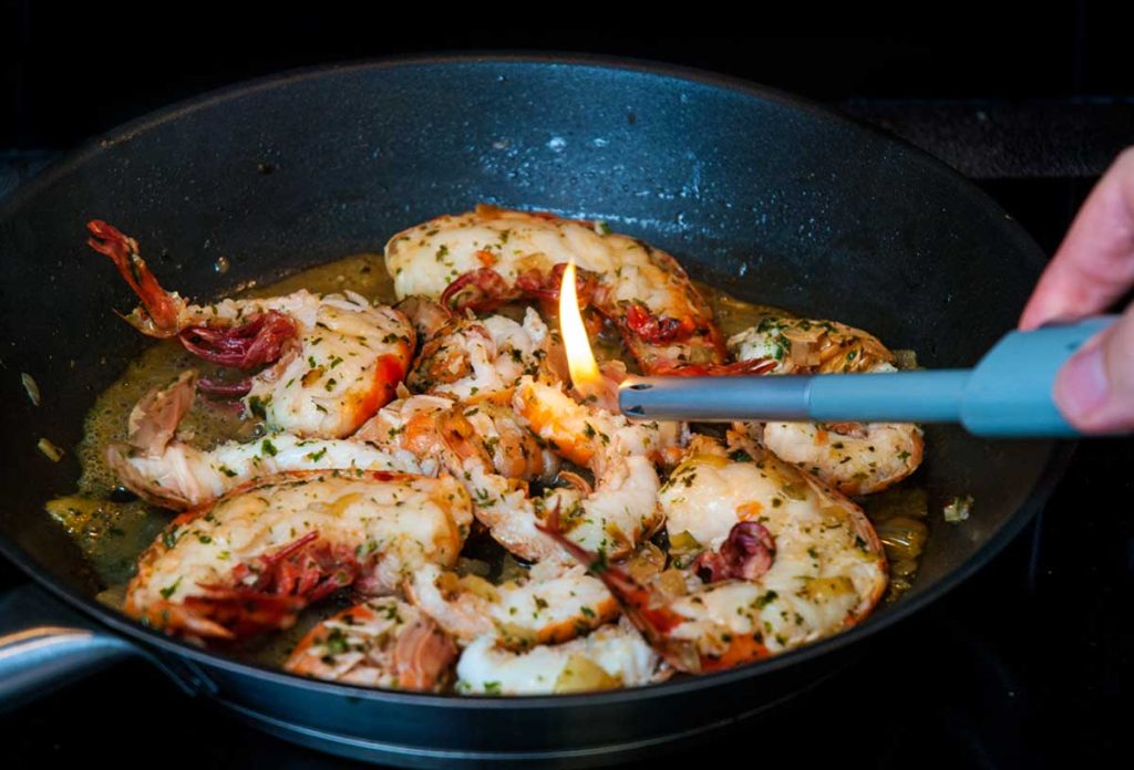 Lighting langoustines and peawns with a long lighter.