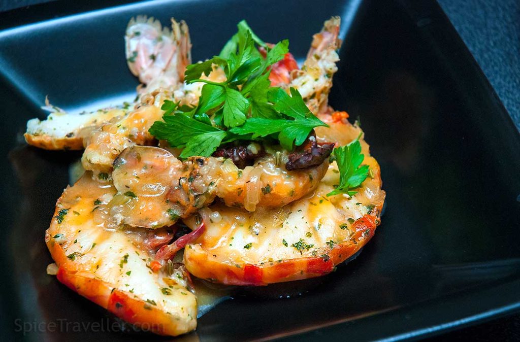 Closeup of the prawn and langoustine tails in rich aromatic sauce.