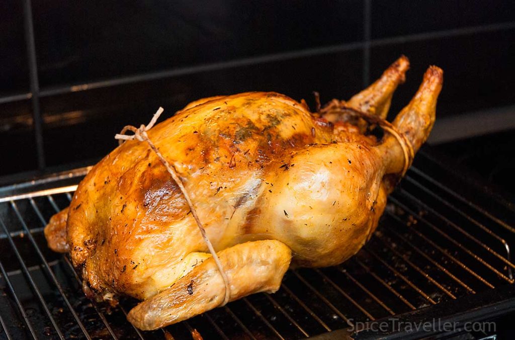 Perfectly roasted delicious and golden whole chicken, still tied, fresh from the oven.