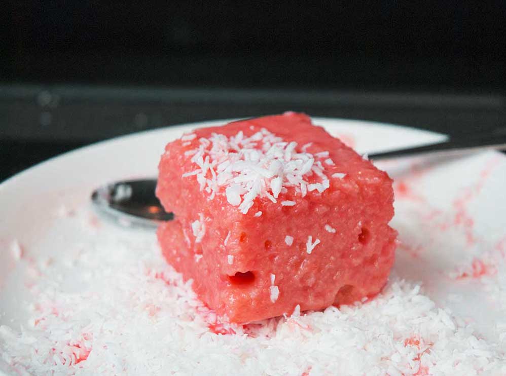 Rum-punch pink Lamington covered with dessicated coconut. 